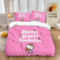 A close-up of a pink polka dot Hello Kitty bedding set featuring Always Choose Kindness text and character with hearts on a white bed.